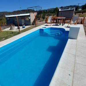 格兰德山谷Balcon al Valle Grande, San Rafael Mendoza的一个带桌椅的蓝色游泳池