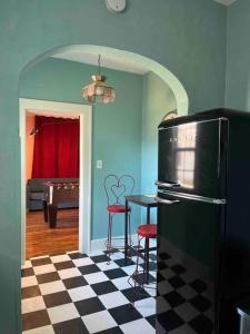 俄克拉何马城Blue Bungalow near OU Med/Downtown的厨房配有黑色冰箱和带凳子的桌子