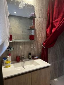 NouaceurLuminous & cosy studio - 5 mins from Mohammed V Airport的浴室设有白色水槽和红色窗帘