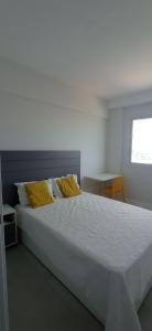 萨尔瓦多Jaguaribe Praia的一间卧室配有一张带黄色枕头的大床
