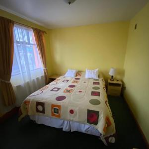 波韦尼尔Hotel Yagan Porvenir的一间卧室配有一张大床和色彩缤纷的被子