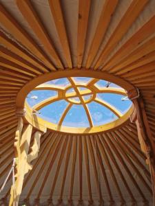 布劳顿弗内斯Wilding Yurt Stay的圆窗,圆窗在蒙古包中,有天花板