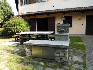 Borgo TicinoAPPARTAMENTO OASI tra LAGHI E MONTI的房屋前的石头烧烤和野餐桌