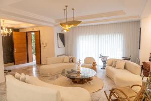 突尼斯Villa Victoria的客厅配有白色家具和玻璃桌