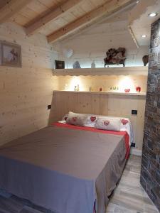 NeuvecelleLe Chalet des 3 Ours的木制客房内的一间卧室,配有一张床