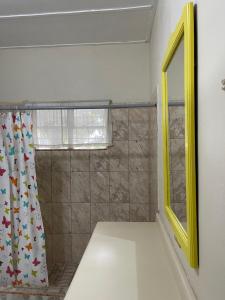 金斯敦Widcombe 8的浴室设有淋浴帘和黄色镜子