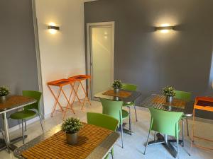 卡利亚里埃利亚的住宿加早餐酒店的一间在客房内配有桌子和绿色椅子的餐厅