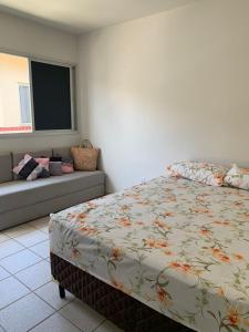瓜拉派瑞Encanto Guarapari的一间卧室配有一张床和一张沙发