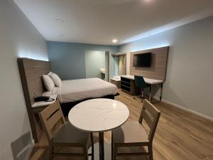 波莫纳Travelodge by Wyndham Fairplex Pomona的小房间设有一张床、一张桌子和一张书桌