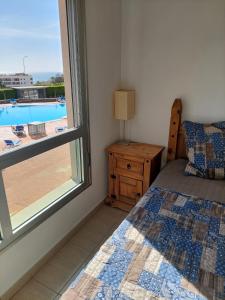 圣米格尔德阿沃纳Sunny Suite的一间卧室设有一张床和一个享有游泳池景致的窗户。