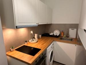 波兹南Rynek 6的小厨房配有白色橱柜和水槽