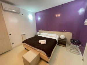 卡利亚里埃利亚的住宿加早餐酒店的一间卧室配有一张大床和紫色墙壁