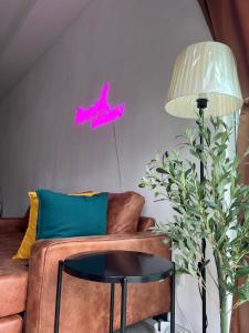 加影Nawwarah Homes @ Southville City (WiFi + NETFLIX)的客厅配有沙发,墙上挂着紫色标志