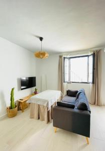 阿洛拉Apartamento La Parra的一间卧室配有一张床、一张桌子和一个窗户。
