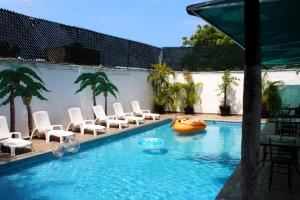 阿卡普尔科D'Cesar Hotel Acapulco的一个带椅子的游泳池,水中还有一条木筏