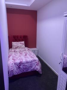 迪拜Paz Holiday Luxurious Space的一间卧室配有一张带紫色棉被的床