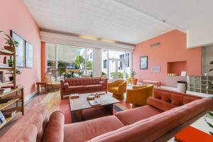 迈阿密海滩Tropics Hotel Miami Beach的客厅设有橙色墙壁和真皮沙发
