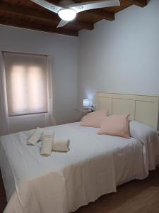 隆达La casita Ronda的卧室配有一张白色大床和两条毛巾