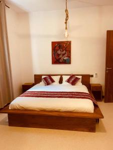 帕杰Oxygen Paje Hotel的一间卧室配有一张大床,配有白色床单和红色枕头