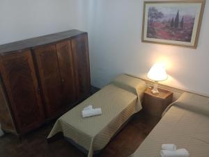 罗萨里奥La Dorada con cochera techada的一间小卧室,配有两张床和一盏灯