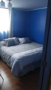特木科Departamento 2 Dormitorios 5 personas, excelente ubicacion的蓝色的卧室,配有一张蓝色墙壁的床