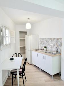 AldaiaApartamentos Aldai Valencia的厨房配有白色家电和桌椅