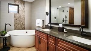 布雷肯里奇Premium Skiing Winter Escape! Upscale Villa Resort的一间带大浴缸和大镜子的浴室