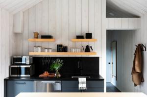 斯托Tälta Lodge, a Bluebird by Lark的厨房配有黑色柜台和微波炉