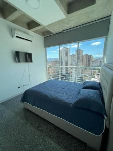 加拉加斯Brand new apt San Bernardino Caracas的一间卧室设有蓝色的床和大窗户
