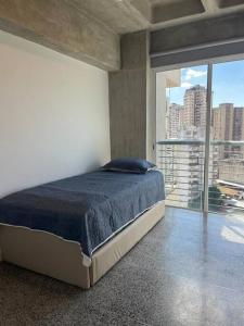 加拉加斯Brand new apt San Bernardino Caracas的一间卧室设有一张床和一个大窗户