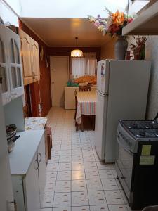 奥索尔诺Cómoda Casa en sector residencial Osorno的厨房配有白色冰箱和桌子
