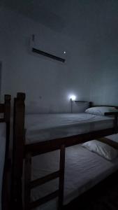 若昂佩索阿Yolo Hostel的墙上有灯的房间里设有两张床