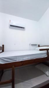 若昂佩索阿Yolo Hostel的白色墙壁间的一张床位