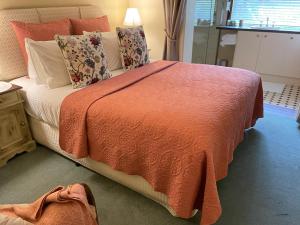 玛格丽特河紫檀木宾馆的一间卧室配有一张带橙色毯子的大床