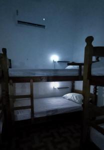 若昂佩索阿Yolo Hostel的黑暗的客房配有两张双层床,光线充足