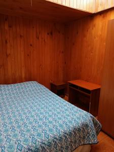 奥索尔诺Cabaña Interior con entrada independiente的一间卧室设有一张床和木墙
