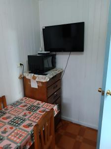 奥索尔诺Cabaña Interior con entrada independiente的客房设有桌子、电视、桌子和桌子。