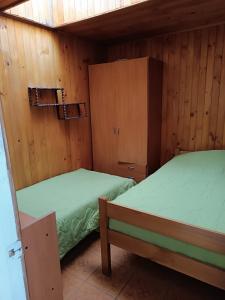 奥索尔诺Cabaña Interior con entrada independiente的木墙客房的两张床