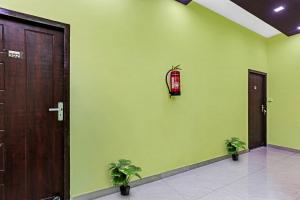 CharbaghCapital O Phenix Elite Near Phoenix United Lucknow的绿色的房间,有两扇门和两棵植物