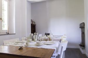卡斯泰莱托索普拉蒂奇诺Il Fiume Azzurro Home B&B的白色的用餐室配有桌子和白色的椅子