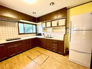 ŌbeBLUE AMALFI - Vacation STAY 28035v的厨房配有木制橱柜和白色冰箱。