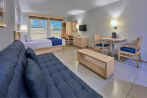 曼萨尼约都市快报曼萨尼约酒店的带沙发、床和桌子的客厅