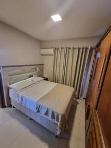 卡波布里奥Apto luxo de 2 quartos, 3 banheiros Praia do forte的一间小卧室,配有床和窗户