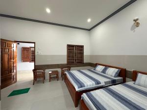 Xóm Moi TrongCát Tú HomeStay的一间卧室配有两张床和一张书桌