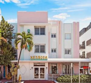 迈阿密海滩Henrosa Hotel的一座白色的大建筑,上面有英雄的标志