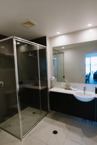 巴利纳Ramada Hotel & Suites by Wyndham Ballina Byron的带淋浴和盥洗盆的浴室