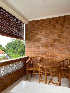 乌布Wahadi homestay的一个带桌椅和砖墙的庭院