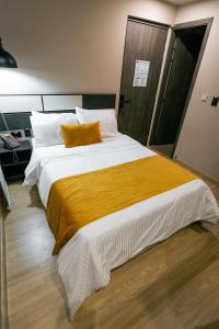 佩雷拉Balmoral Plaza Hotel的一间卧室配有一张带黄色毯子的大床