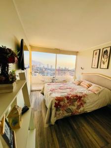 伊基克Departamento con espectacular Ubicación, Vista al Mar y Panorámica a todo Iquique的一间卧室设有一张床和一个大窗户