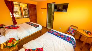 库斯科Andean Atoq Hostel的客房设有两张床和一张带镜子的桌子